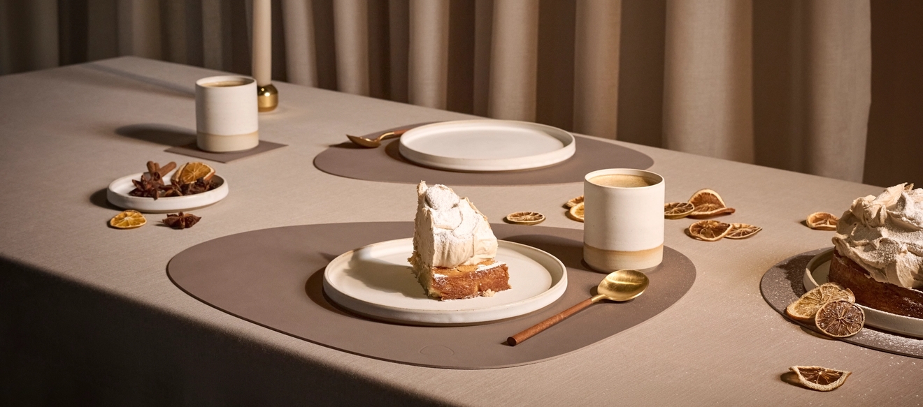 Ett bord dukat med bordstabletter och assietter med kaka på