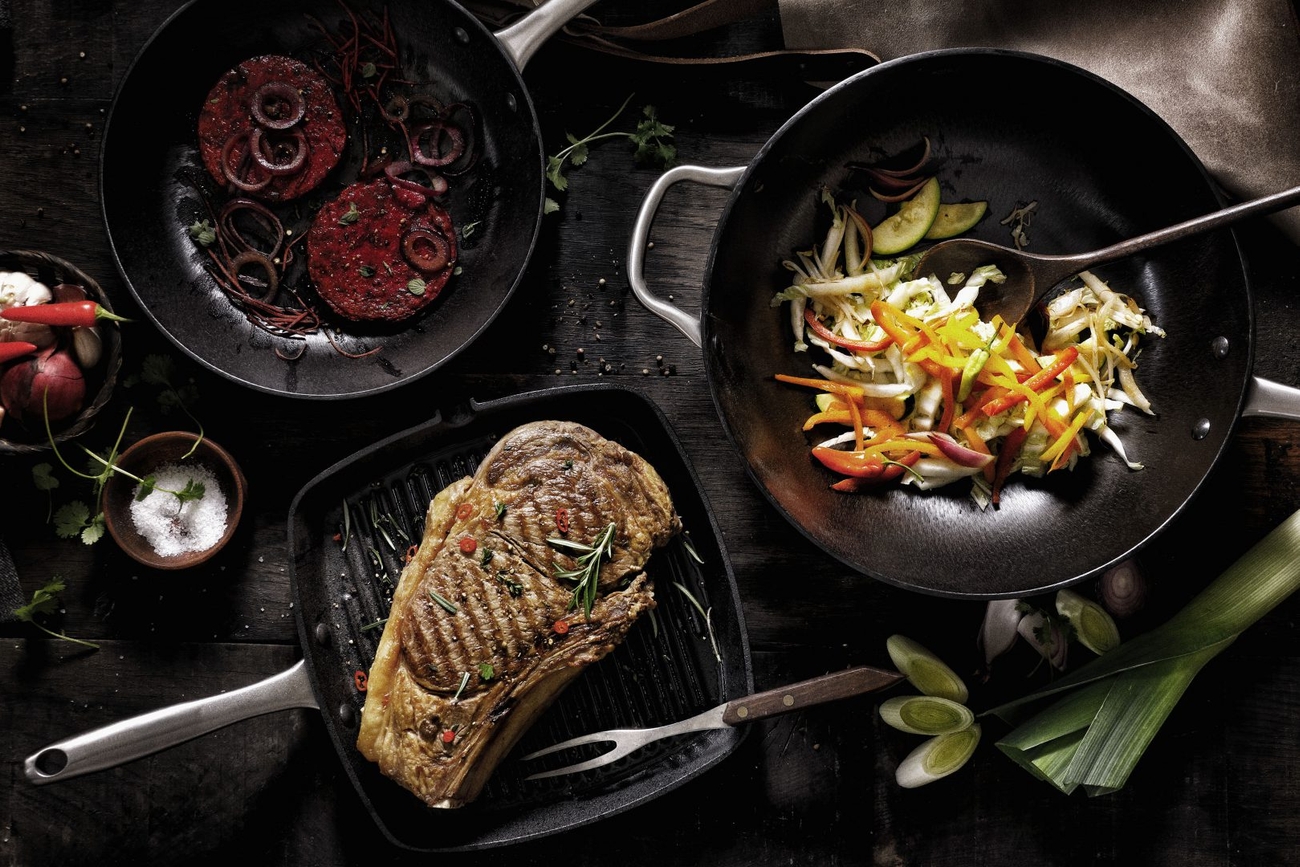 a table topped with pans filled with food and vegetables .
