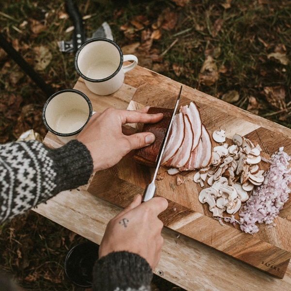 Ulkoilu ja retkeilä ruoanlaitto ulkona puisella leikkuulaudalla
