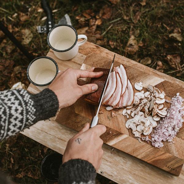 Ulkoilu ja retkeilä ruoanlaitto ulkona puisella leikkuulaudalla