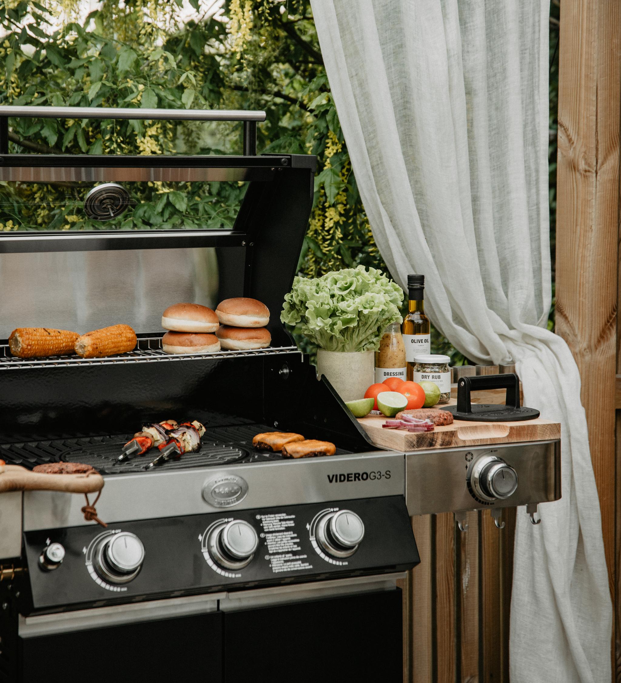 Grill med hamburgare och grönsaksspett som grillas