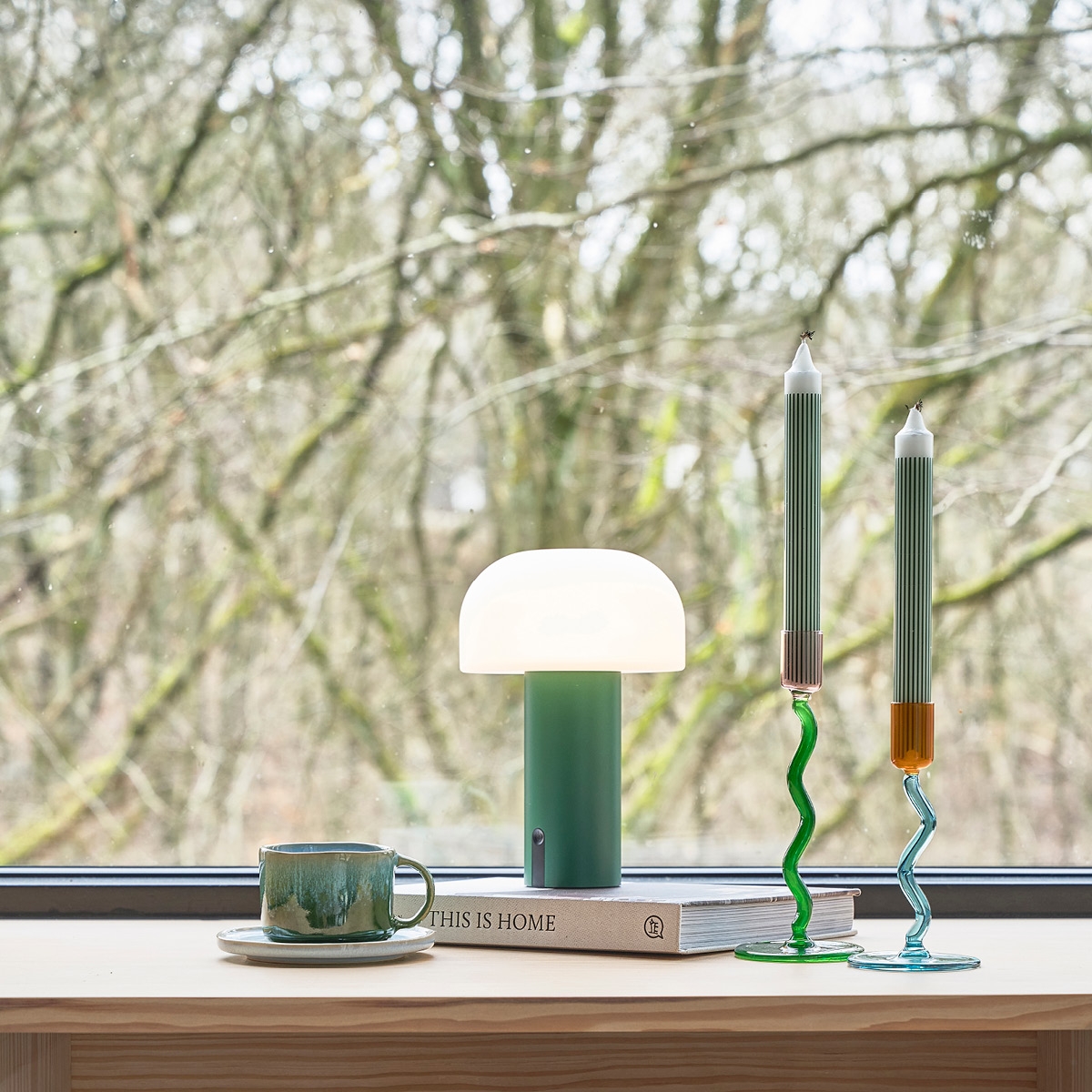 Sladdlös lampa i vitt ståendes på en träbänk med en beige bakgrund