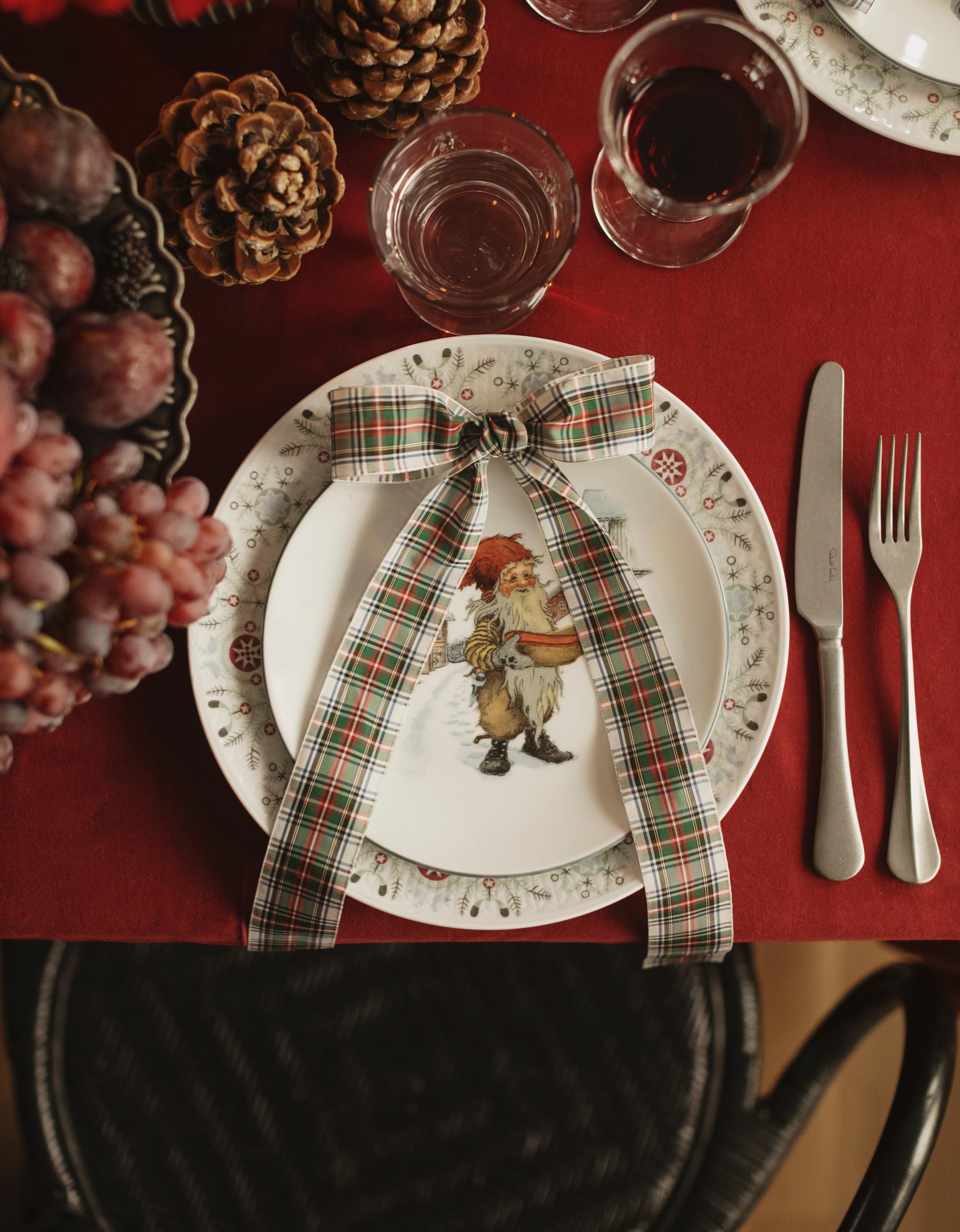 a christmas place setting with a plate with a picture of santa on it