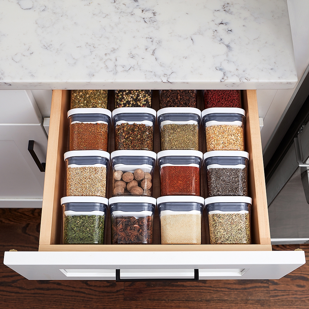 Krydder i gjennomsiktige bokser med hvite lokk