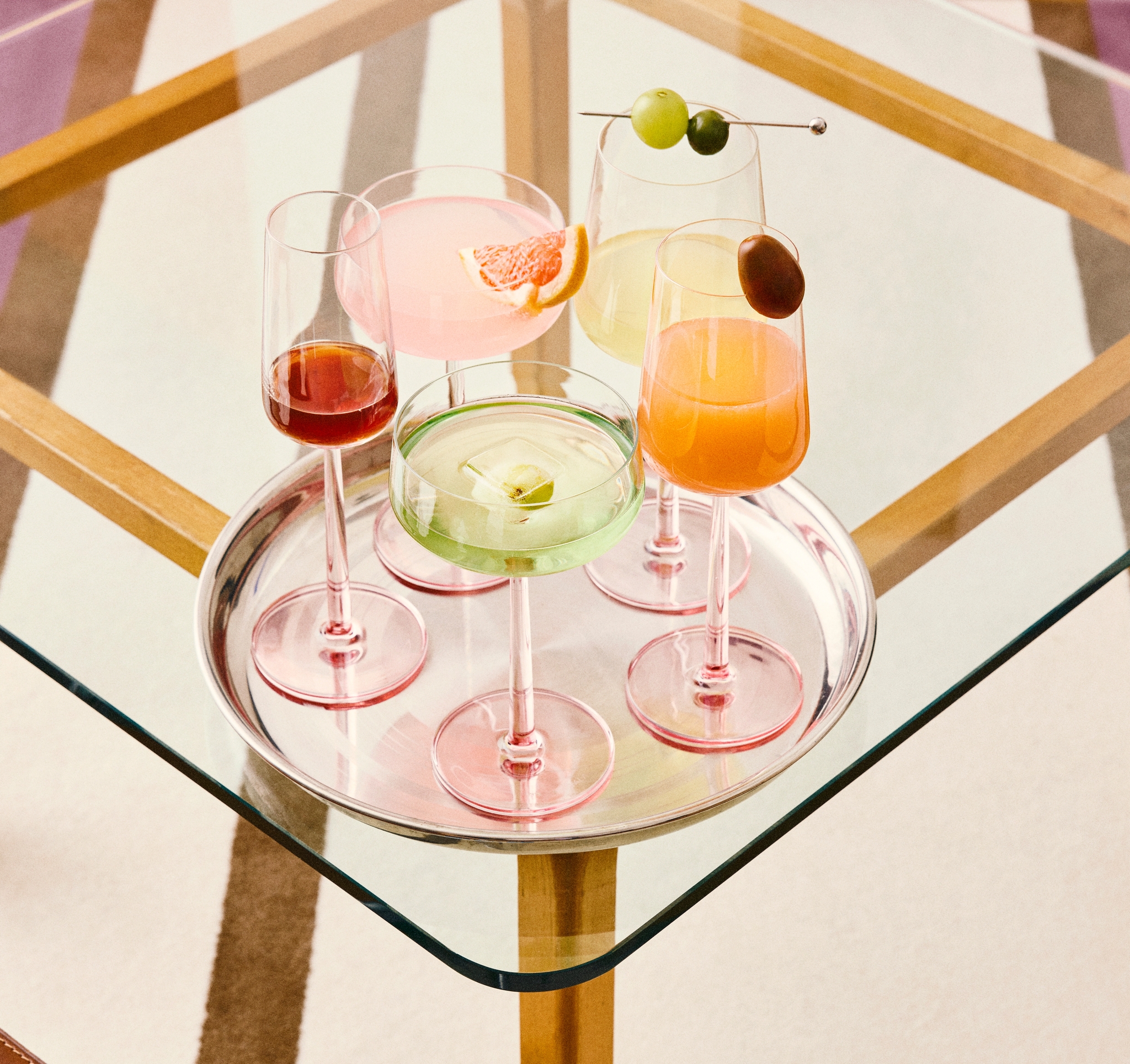 Vin- och cocktailglas med rosa fot på en silverbricka