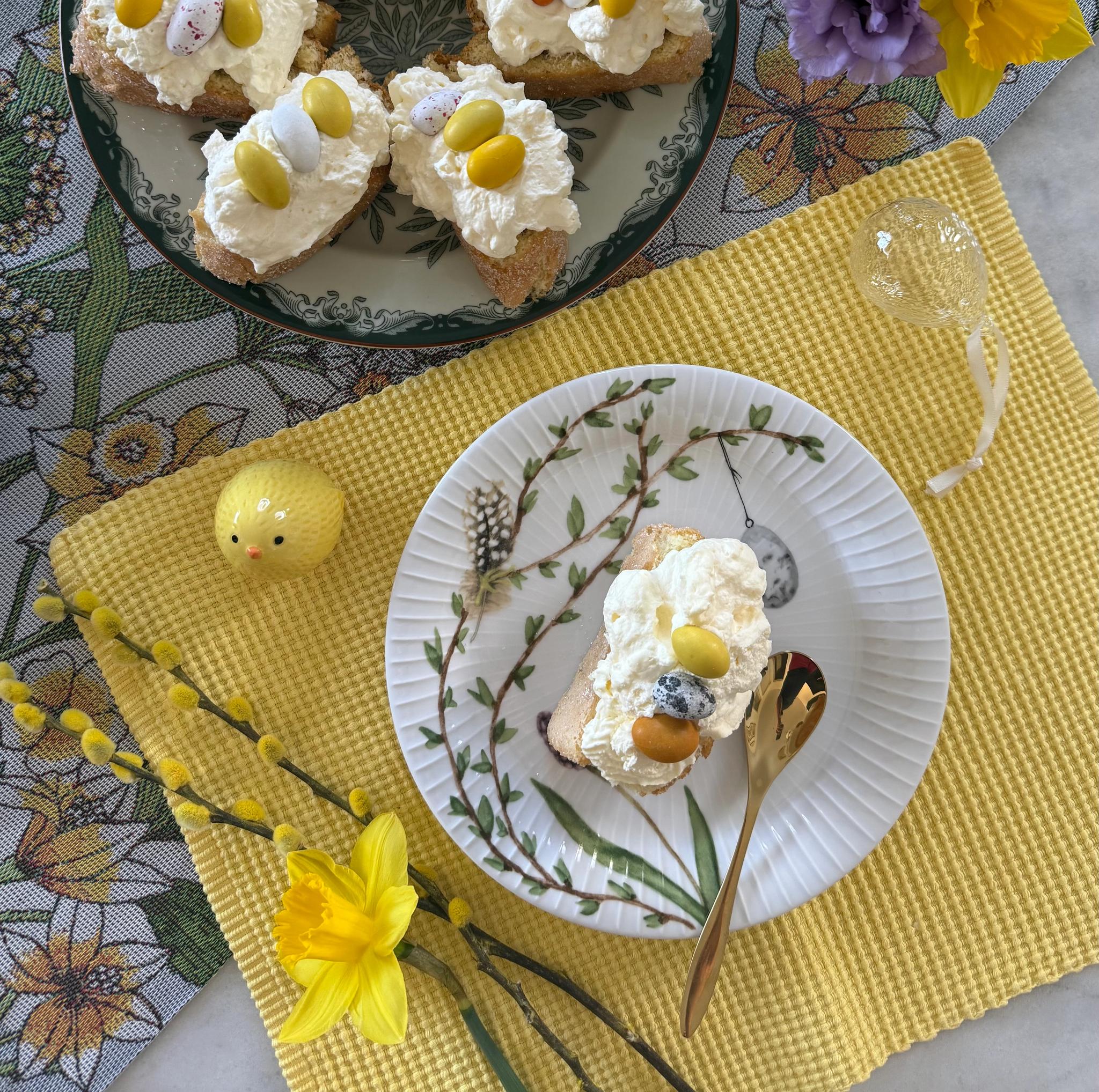 Randig rulltårta med hallon uppdukad på bord till påsk