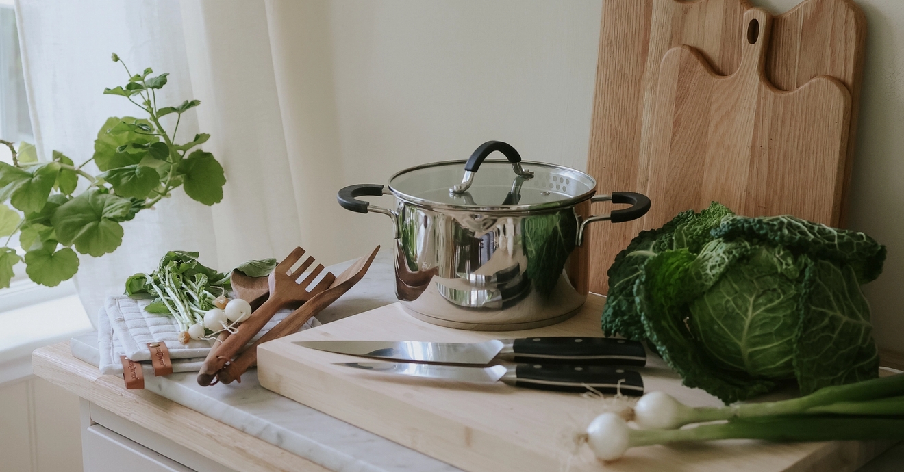 Köksredskap, knivar, skärbräda och kastrull i ett somrigt kök