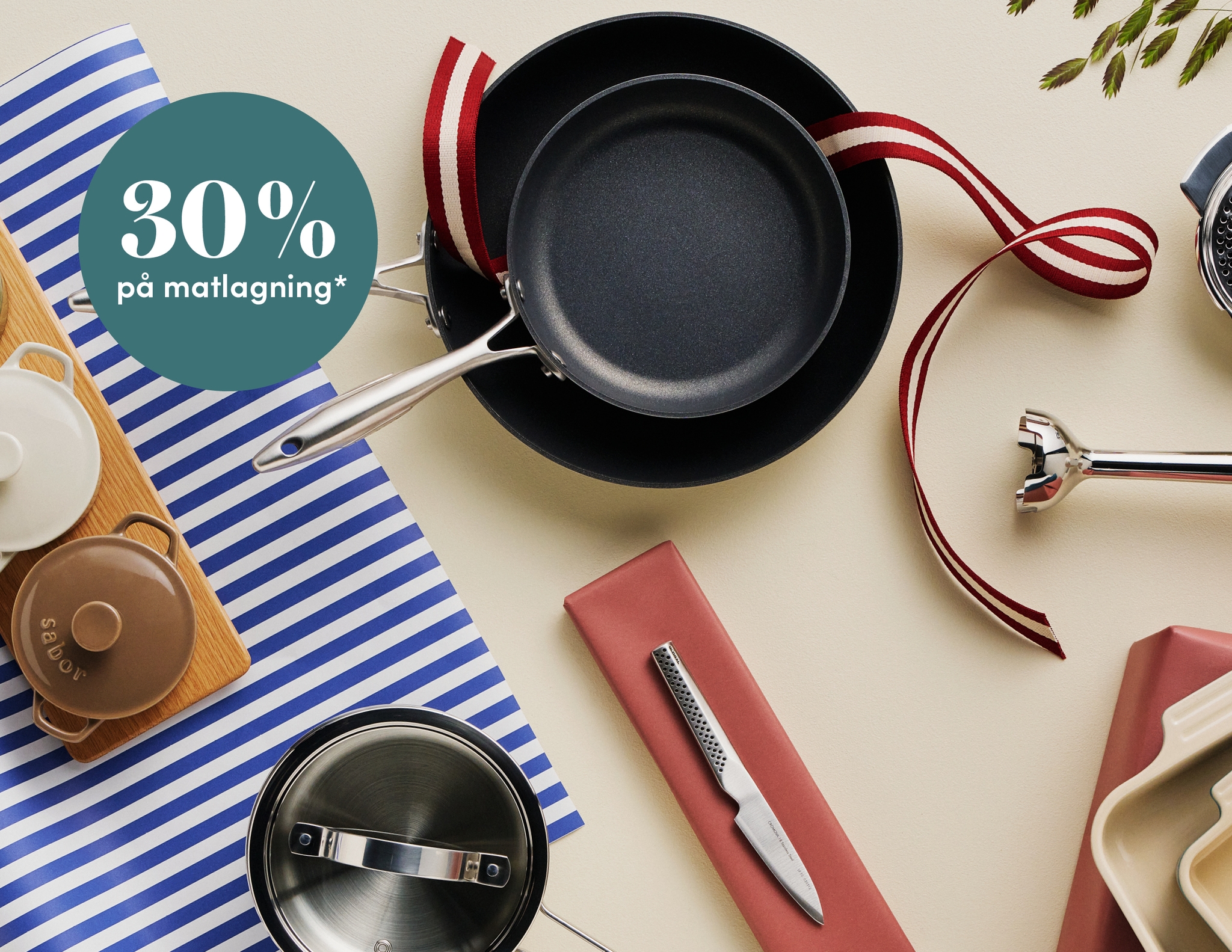Köksredskap och stekpannor arrangerade på ett bord med texten '30 % på matlagning'.