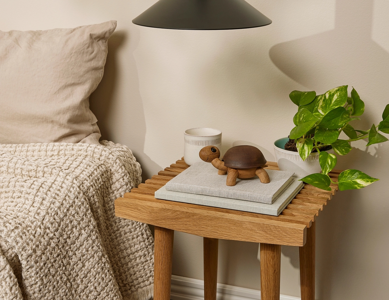 ett sovrum med ett litet träbord med en dekorationssköldpadda ovanpå