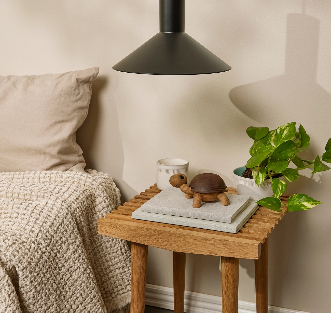 ett sovrum med ett litet träbord med en dekorationssköldpadda ovanpå