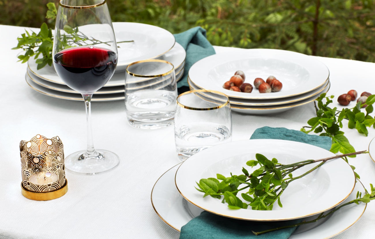 Kultareunaiset lautaset tyylipuhdas kattaus 