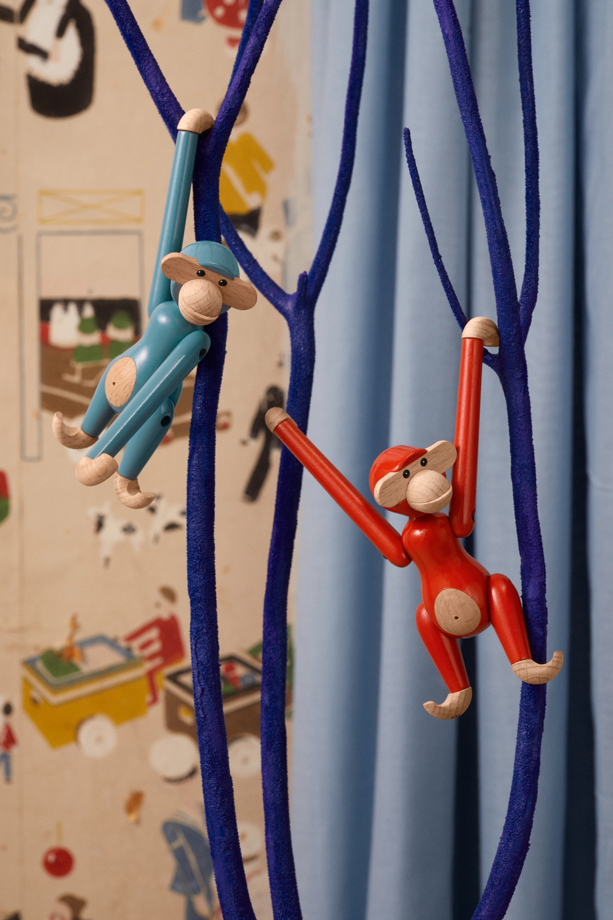 Barnrum med Kaj Bojesen apor i blått och rött hängandes i en trädliknande ställning