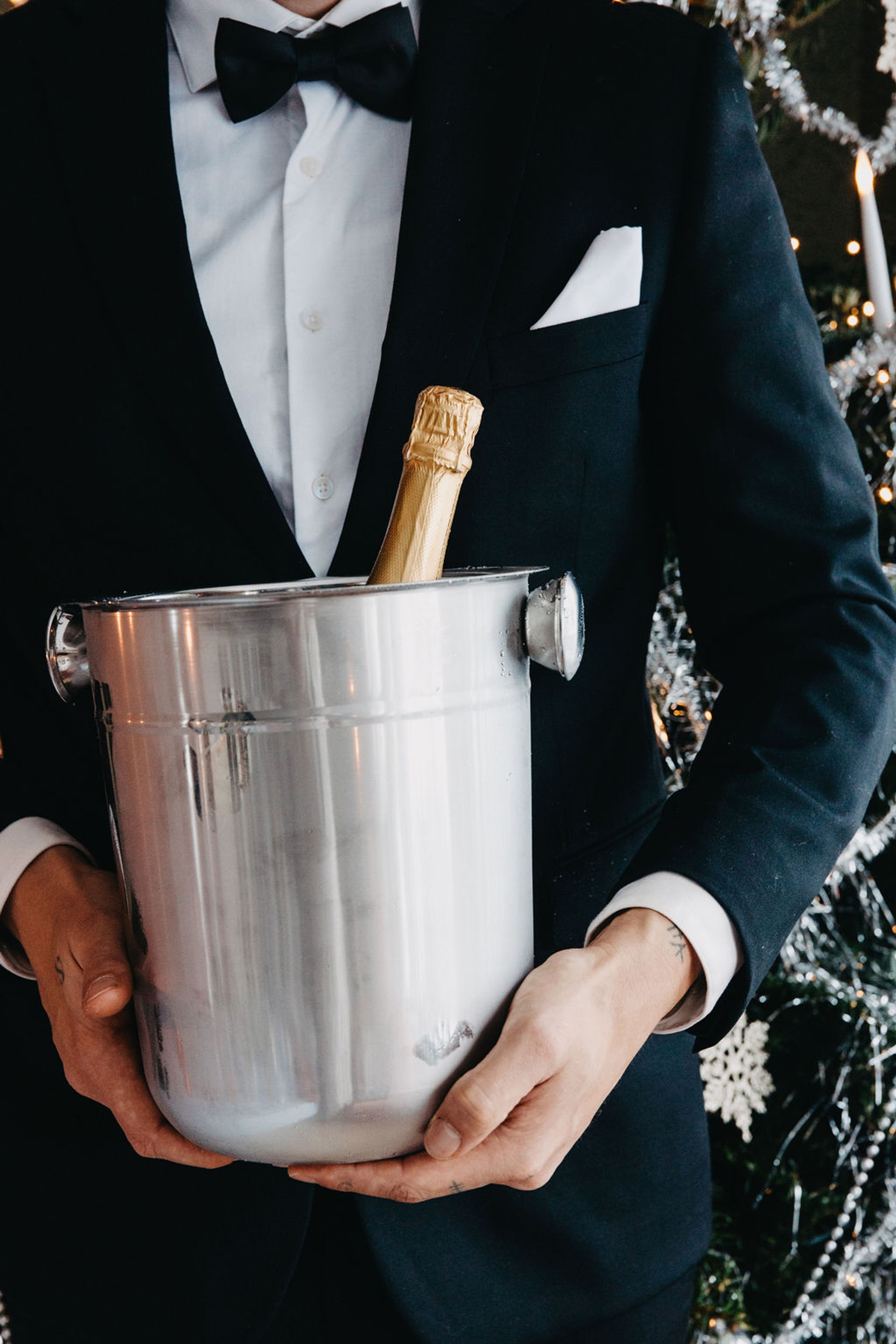 Stilig man med kostym hållandes i champagnehink