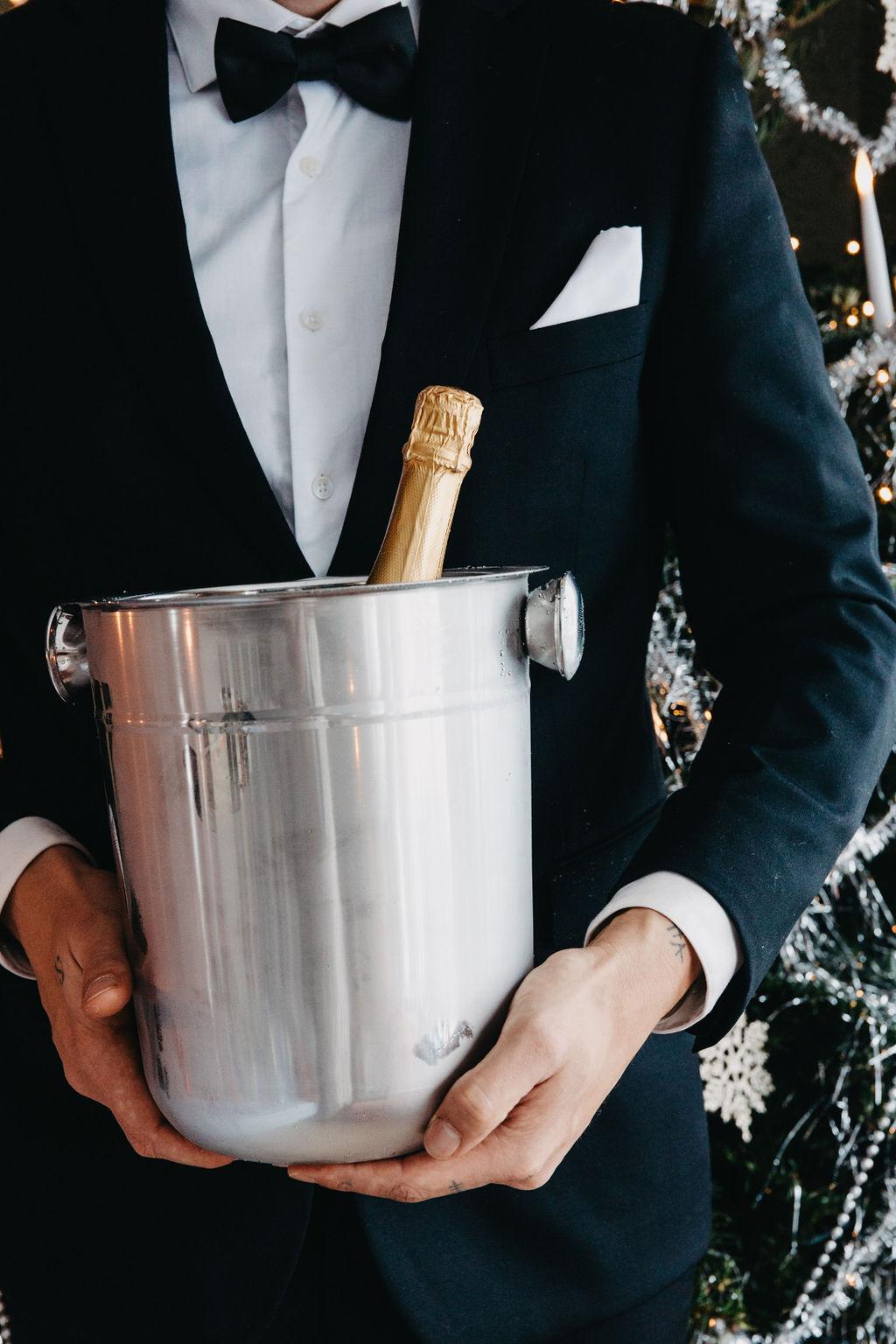 Stilig man med kostym hållandes i champagnehink