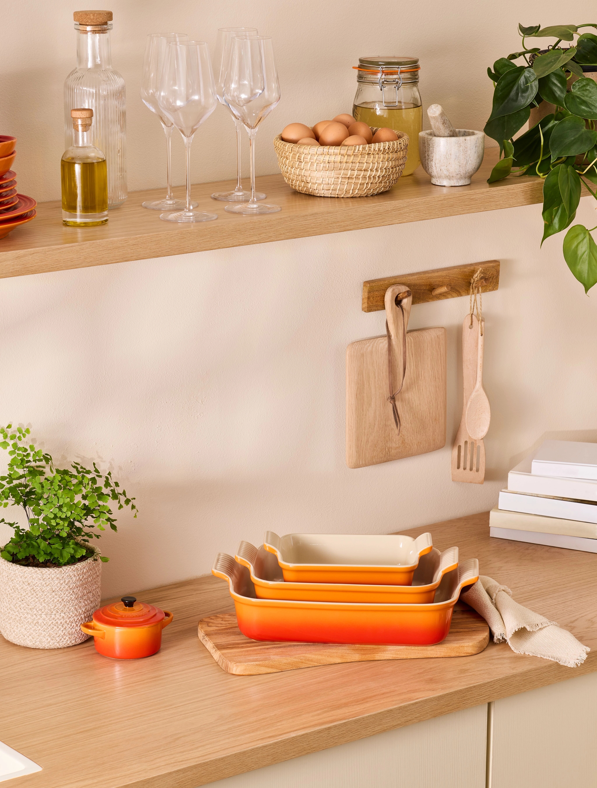 Oransje ildfast form fra Le Creuset som står på en kjøkkenbenk i tre
