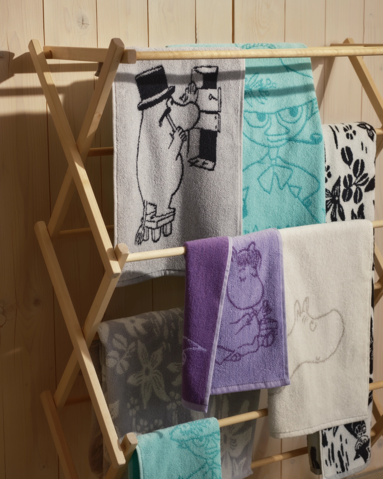 Kylpyhuonetarvikkeet pyyhkeet eri väreissä kuivaustelineellä