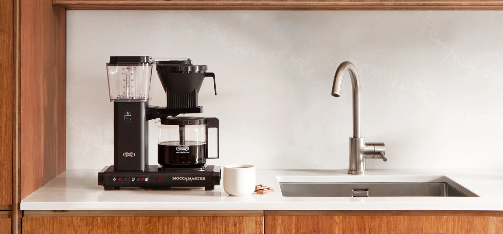 Moccamaster kaffebryggare i silver med swedish grace muggar bredvid