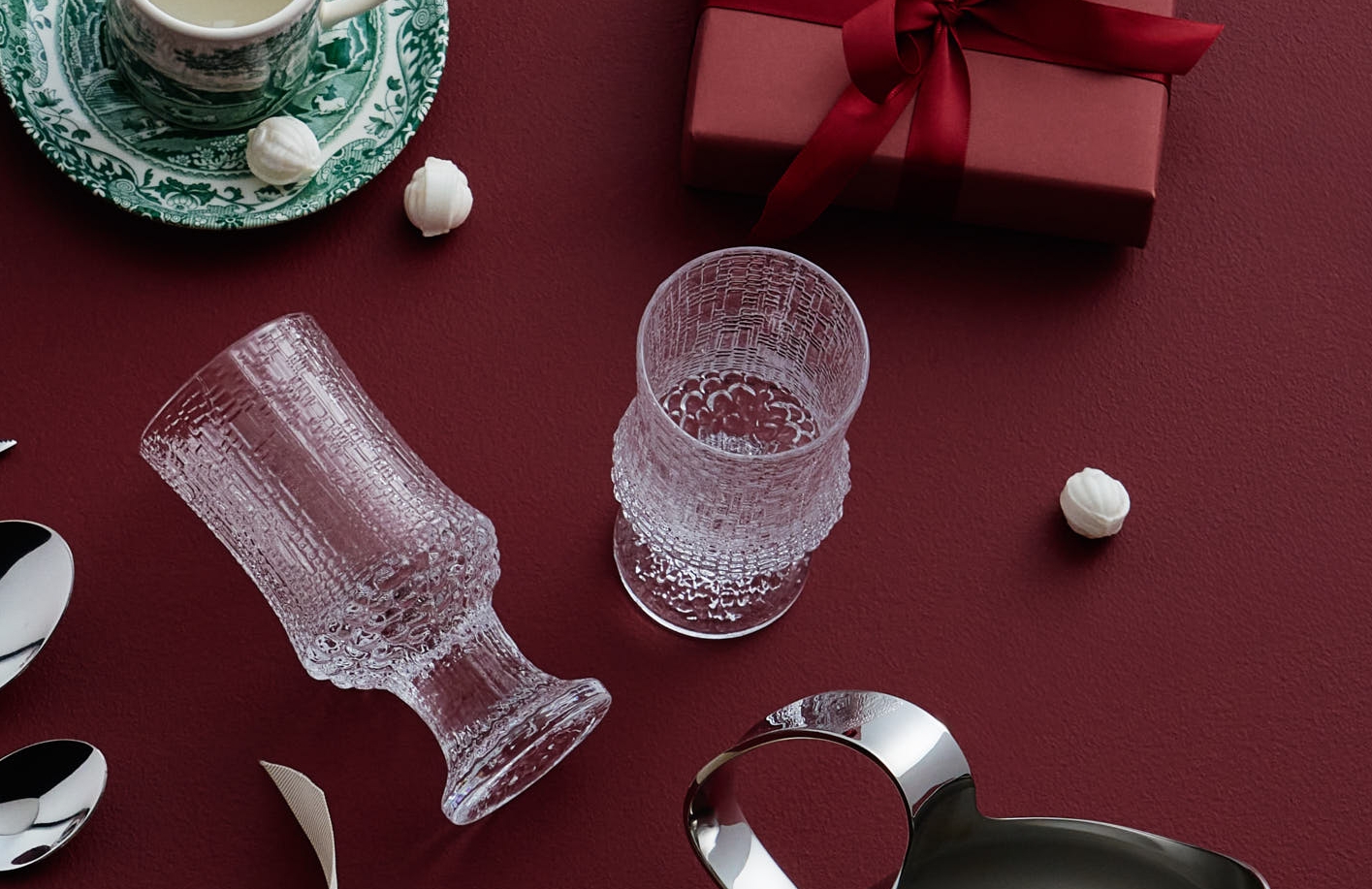 Ölglas från Iittala Kastehelmi och ett rött inslaget paket mot en röd bakgrund