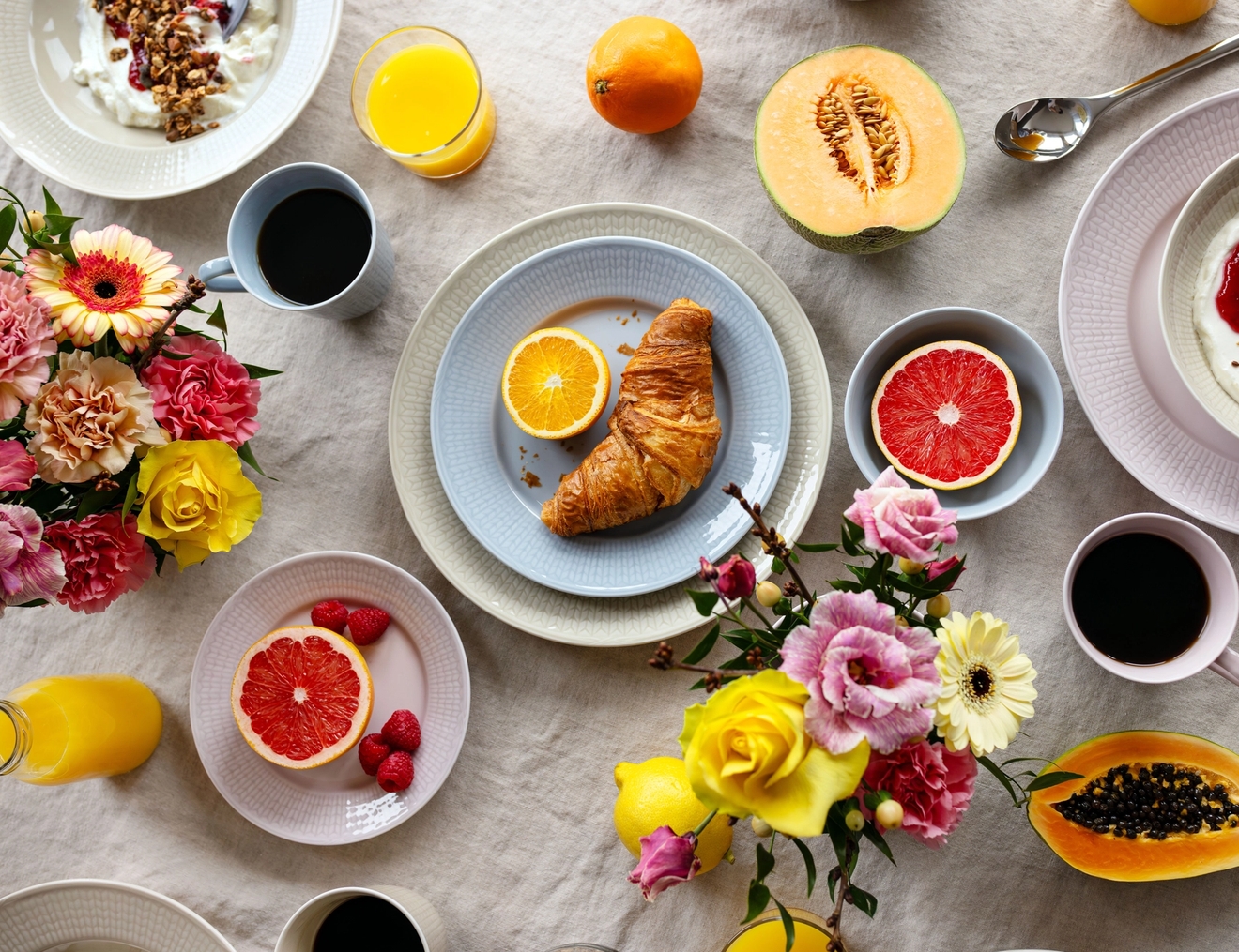 Swedish Grace Is dekket på et bord med fargerik frukt og blomster