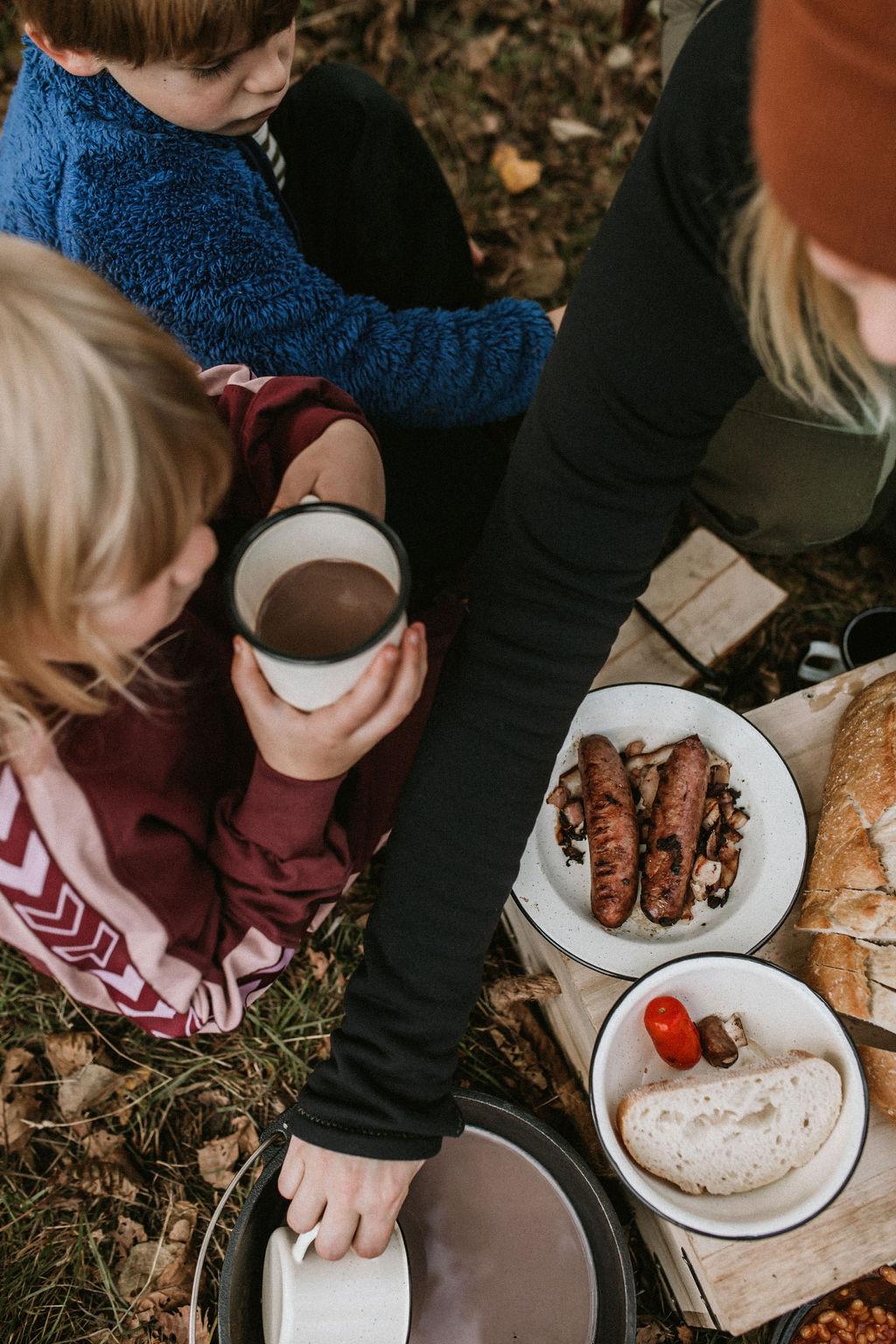 Ulkoilu ja retkeily kuuma kaakao ja grillatut makkarat