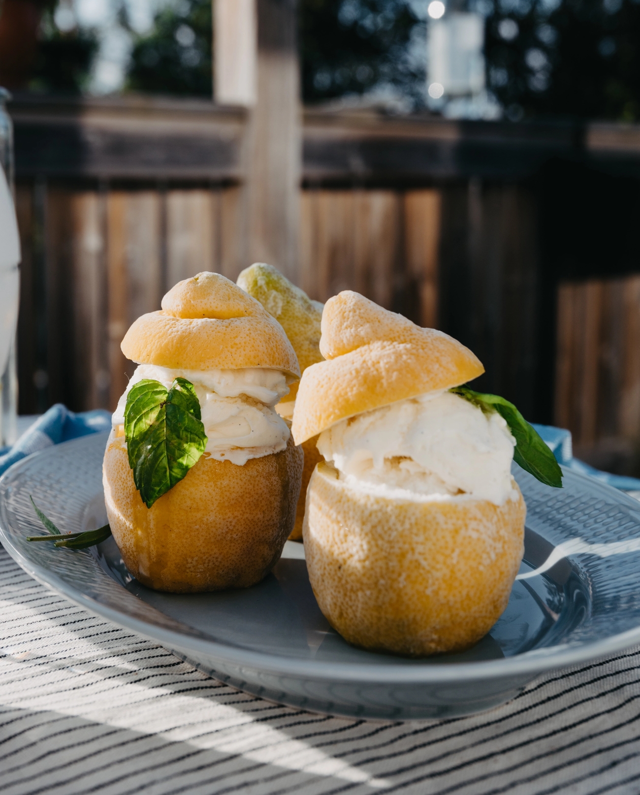 Jäätelöä yllin kyllin jääsitruunat tarjoiluastialla raidallisella pöytäliinalla