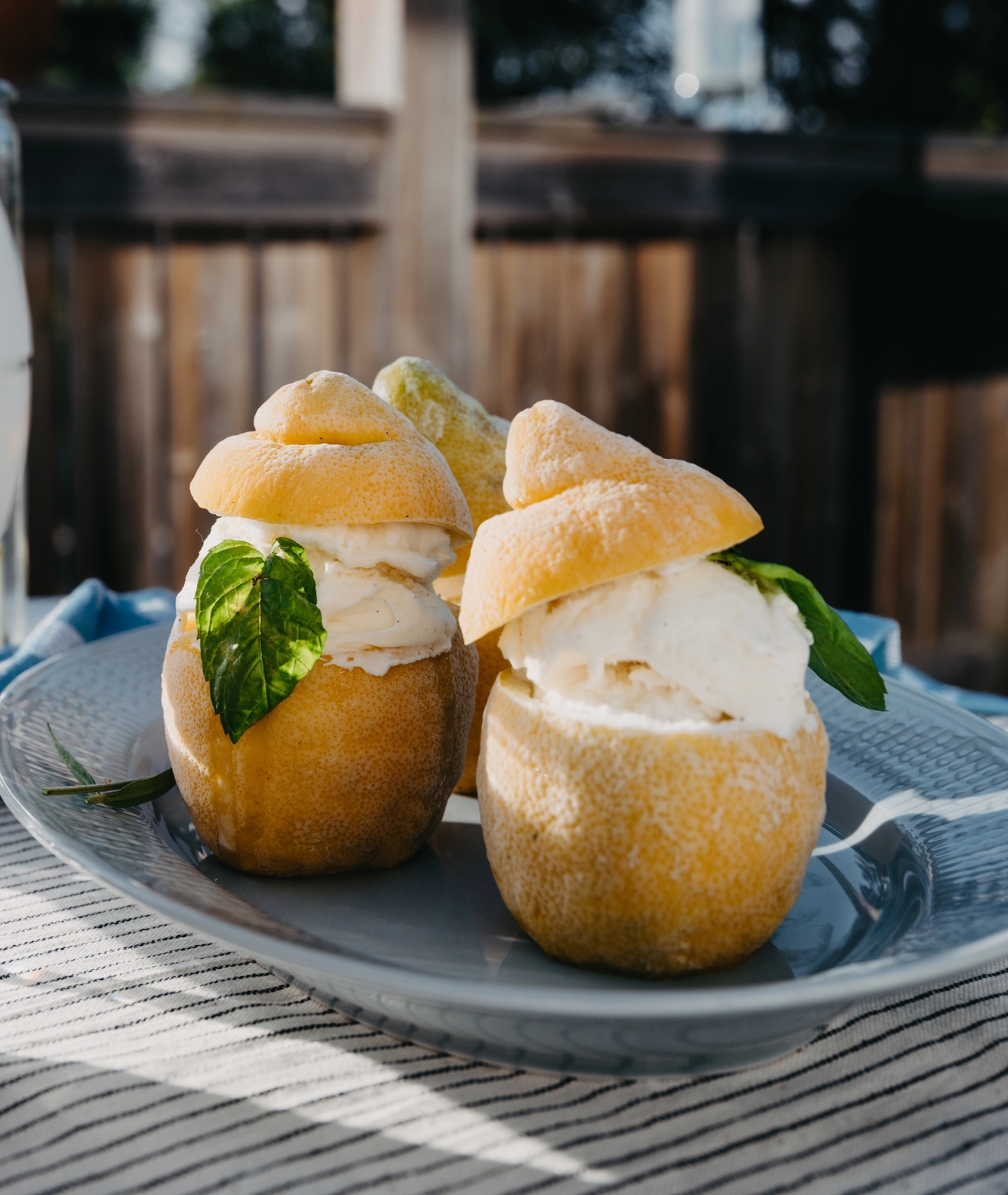 Jäätelöä yllin kyllin jääsitruunat tarjoiluastialla raidallisella pöytäliinalla