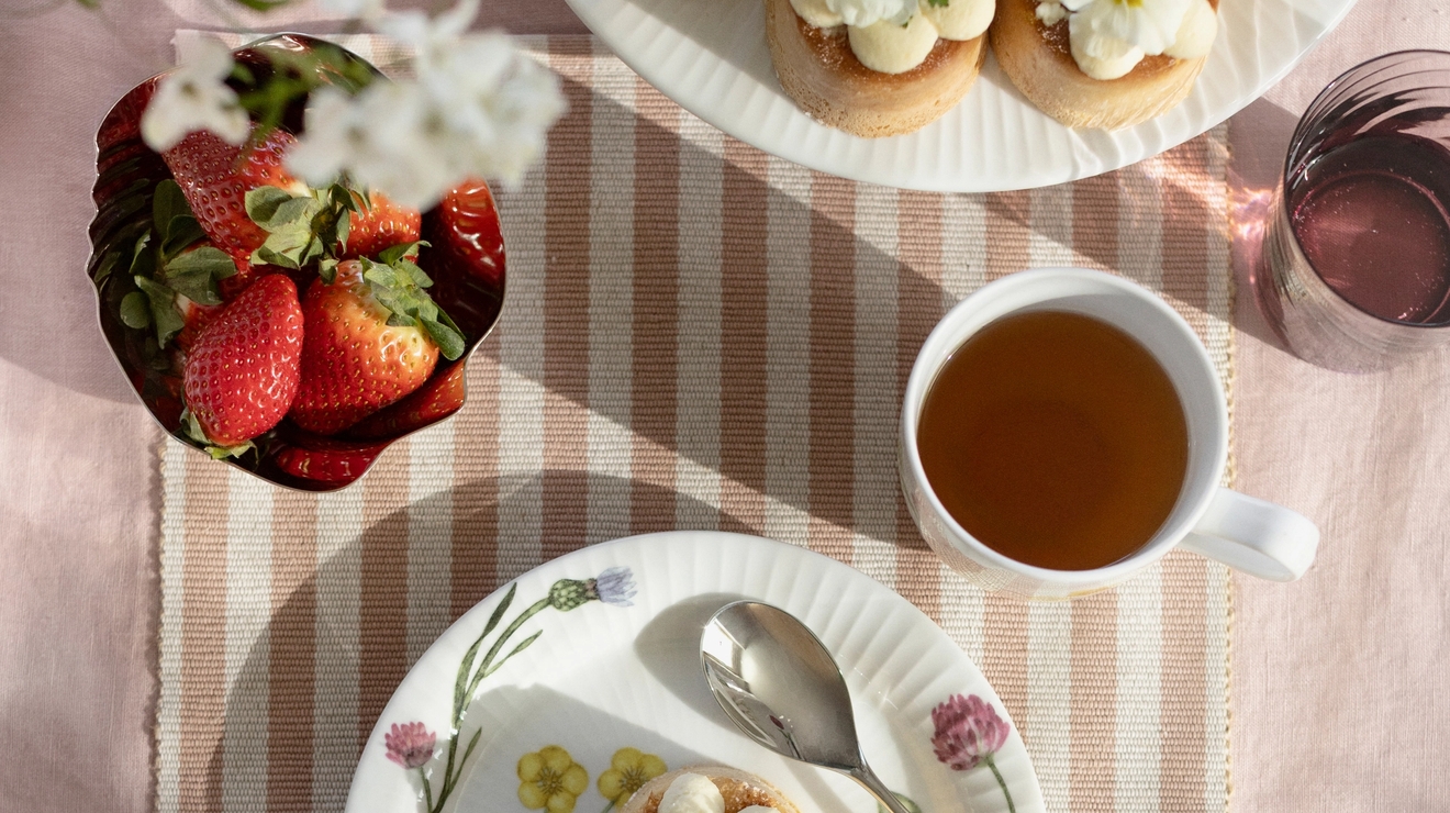 Pöytäliina ja raidallinen kaitaliina kahvipöydässä