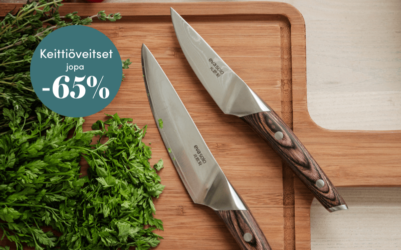 Kaksi keittiöveistä puisella leikkuulaudalla yrttien kera 