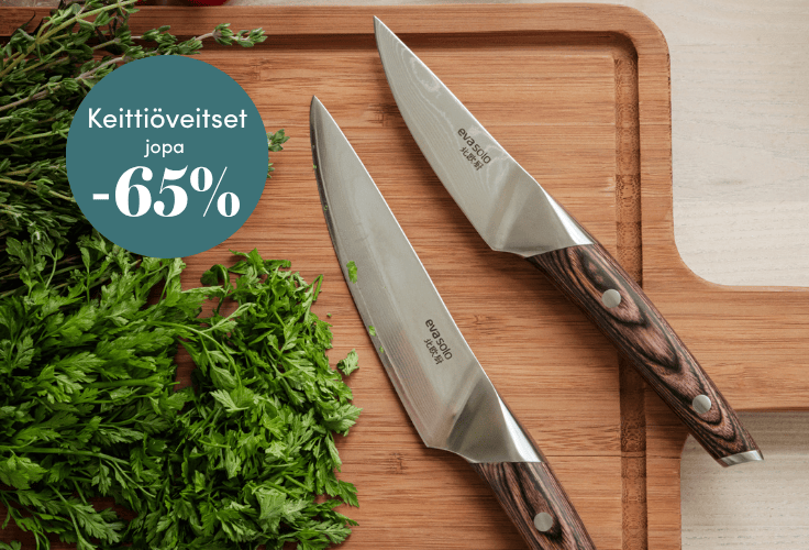 Kaksi keittiöveistä puisella leikkuulaudalla yrttien kera