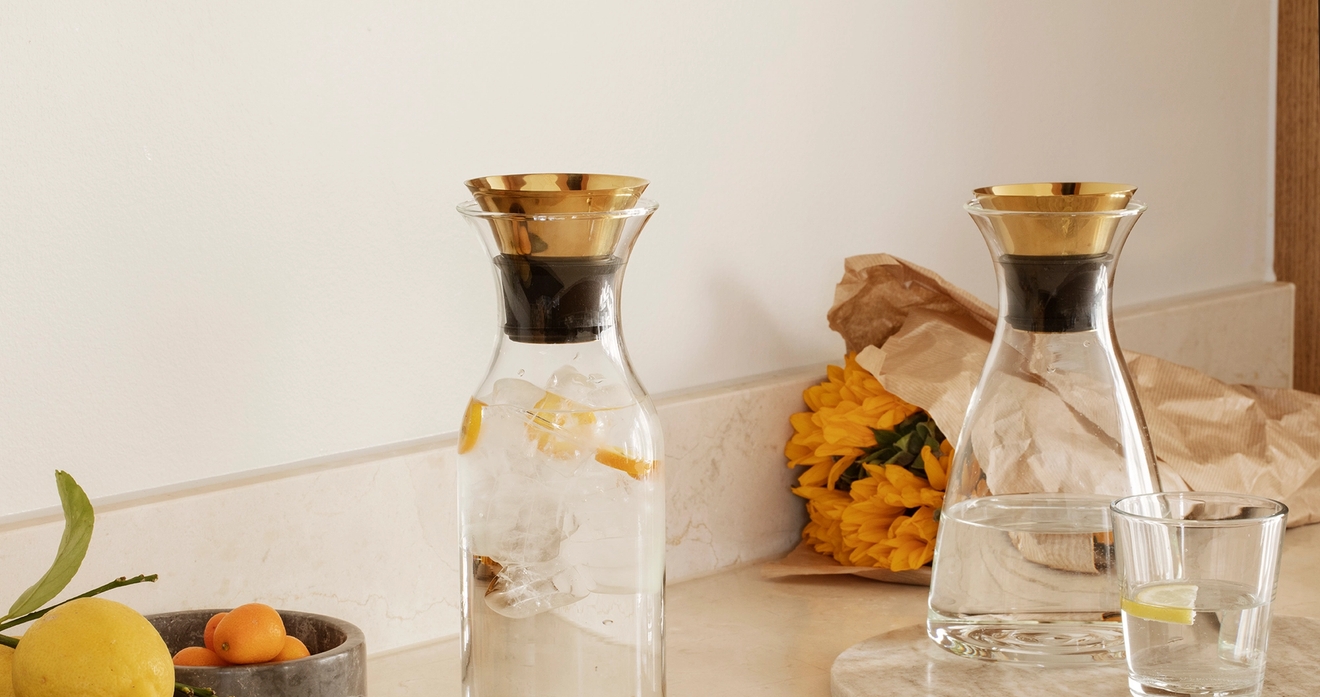 Lasinen Eva solo karahvi kultaisella korkilla marmorisella keittiön työtasolla