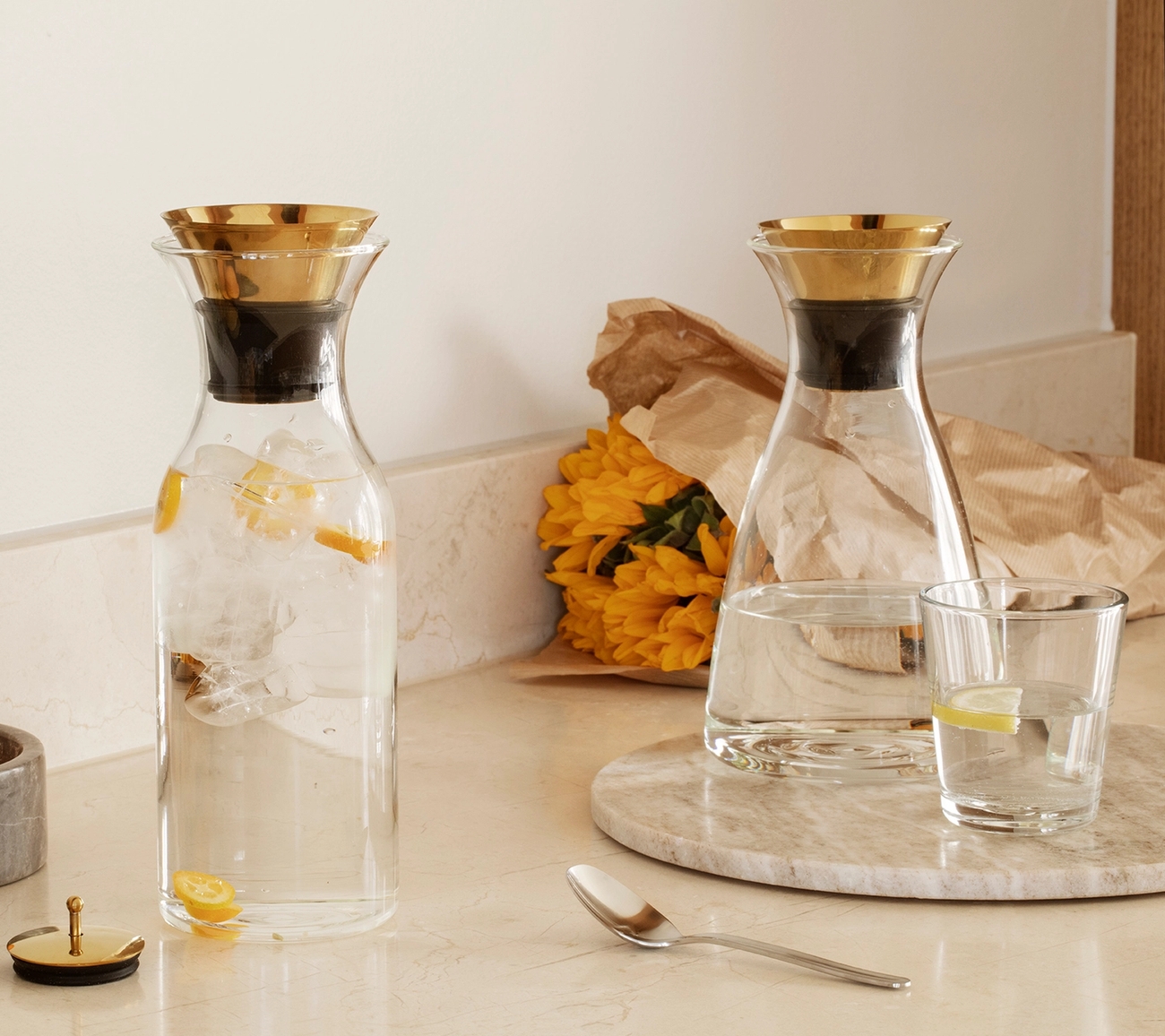 Lasinen Eva solo karahvi kultaisella korkilla marmorisella keittiön työtasolla