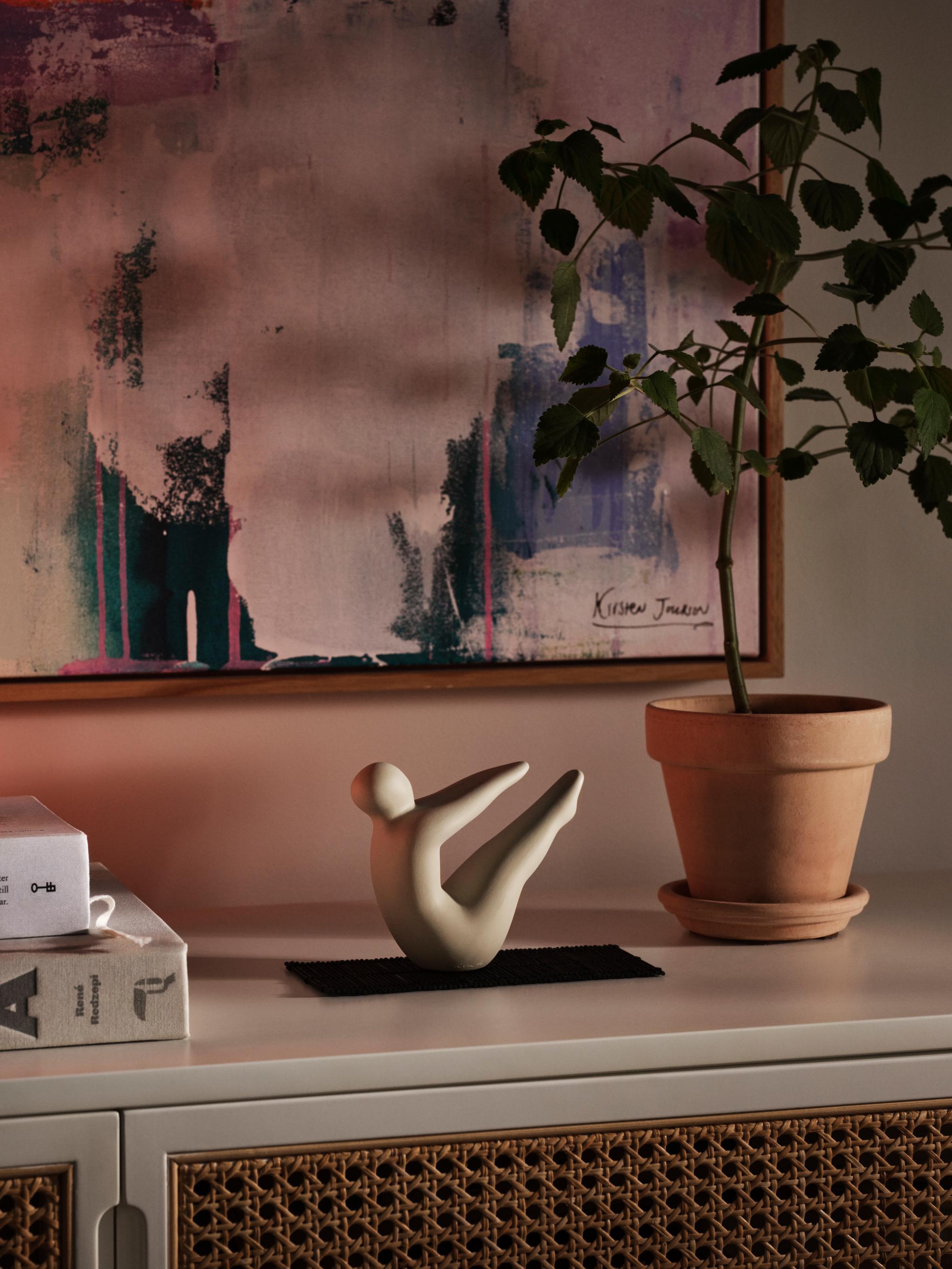 Lisa Larson Yoga-figur nr2 i ljusgrått på ett sidobord