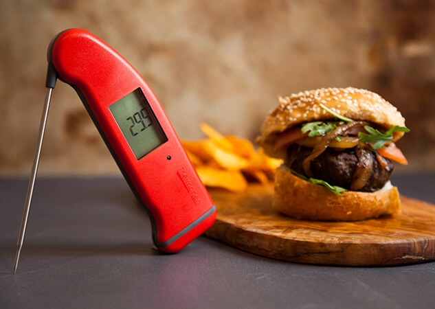 Timere og termometre i rødt sammen med en hamburger