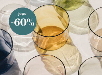 Värikkäät juomalasit aseteltuna pöydälle ja vihreä merkki, jossa lukee jopa -60 % alennus.