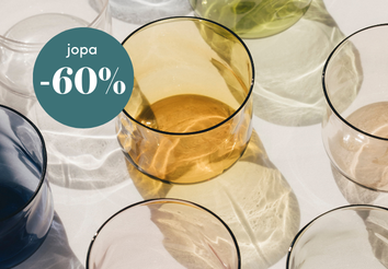 Värikkäät juomalasit aseteltuna pöydälle ja vihreä merkki, jossa lukee jopa -60 % alennus.