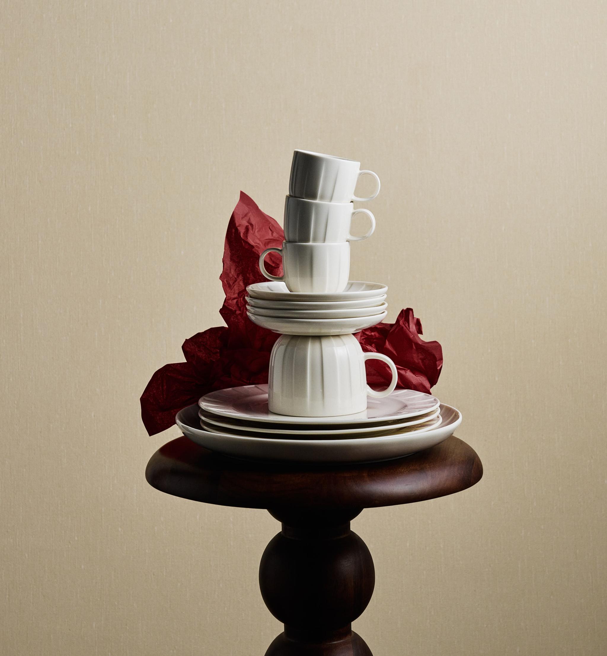 Servisen Stiernholm koppar och fat staplade på varandra på en pidestal