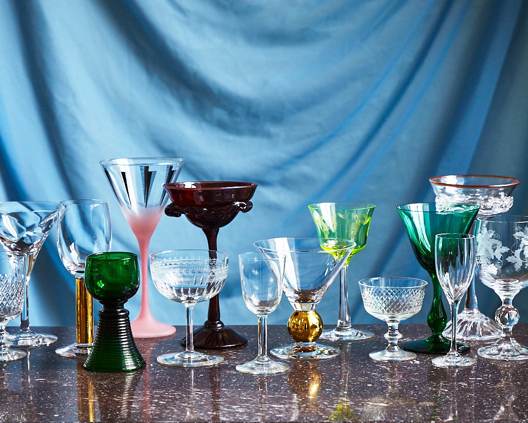 Glas i olika storlekar och former uppställda mot en blå bakgrund