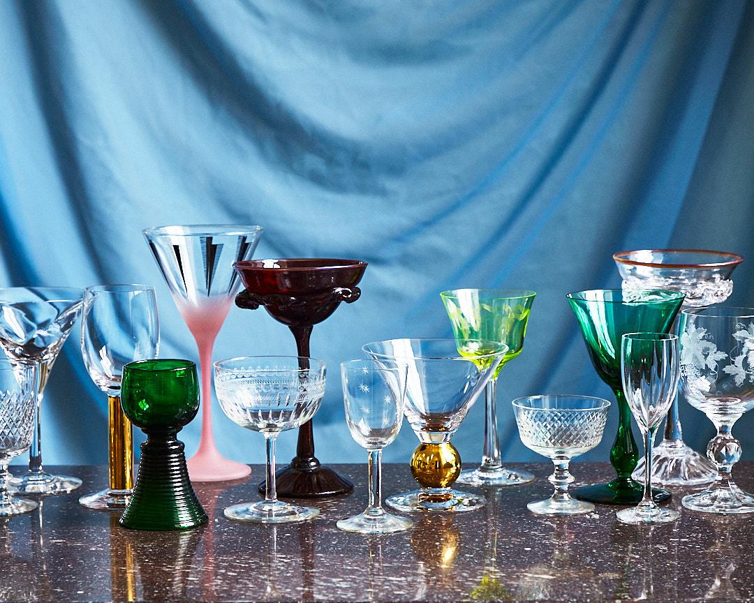 Glas i olika storlekar och former uppställda mot en blå bakgrund
