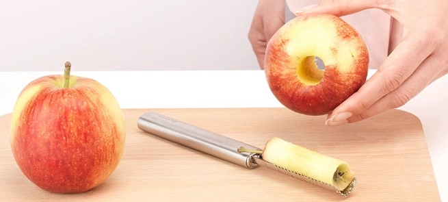 Urkärnare, äpplen på skärbräda i trä ett urkärnat