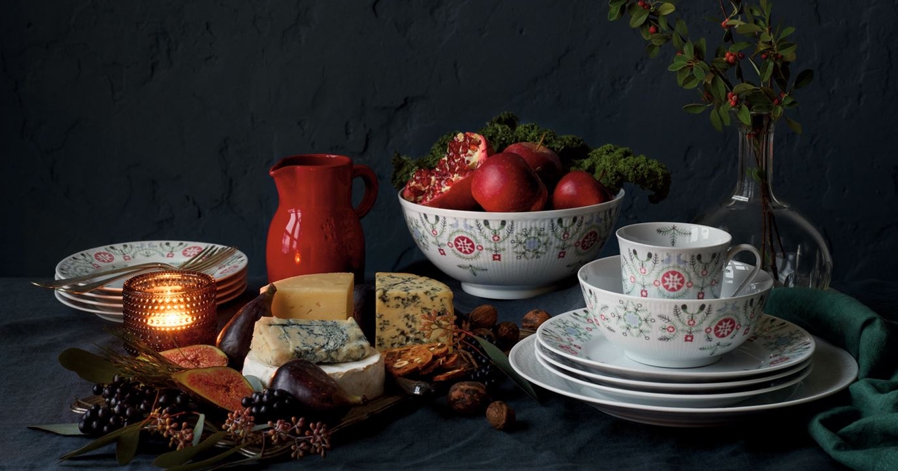 Ett bord dukat med juliga delikatesser och porslin från Swedish Grace Winter