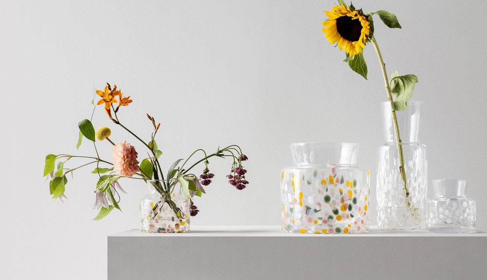 Värikkäitä lasimaljakoita, joissa on kesäkukkia