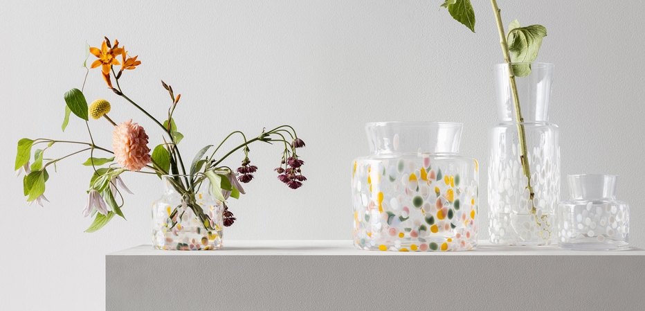 Värikkäitä lasimaljakoita, joissa on kesäkukkia