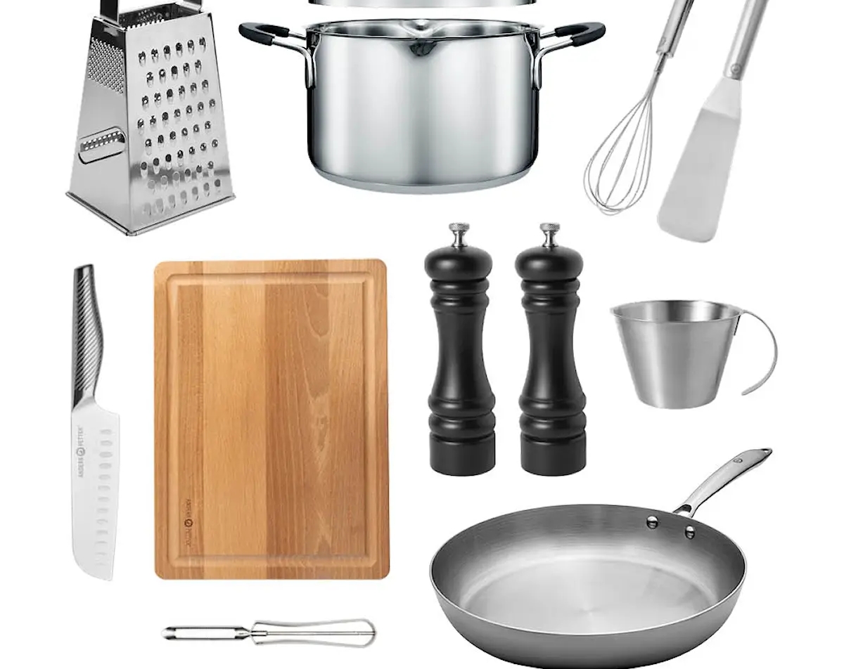 Uppsättning köksredskap med kastrull, stekpanna, rivjärn, skärbräda, kniv, visp, stekspade, skalare, måttkanna och salt- och pepparkvarnar på vit bakgrund.