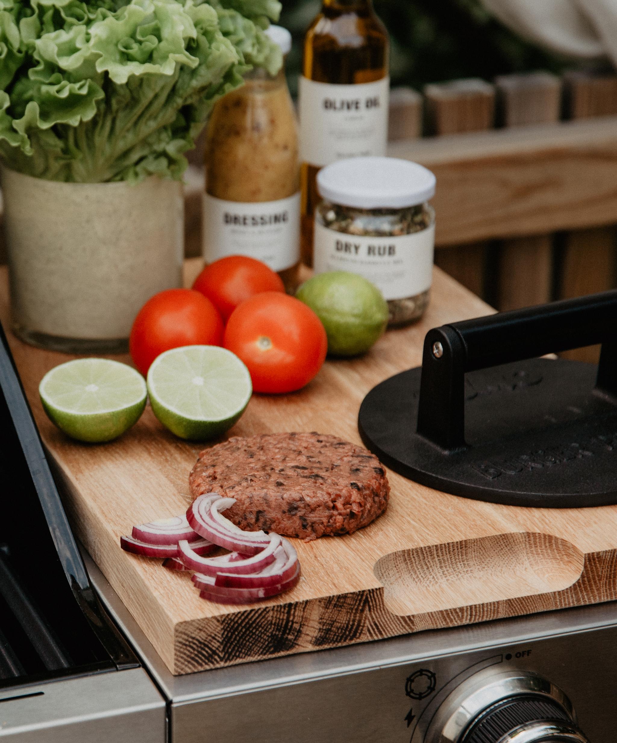 Grillade burgare och tillbehör på en utomhusgrill