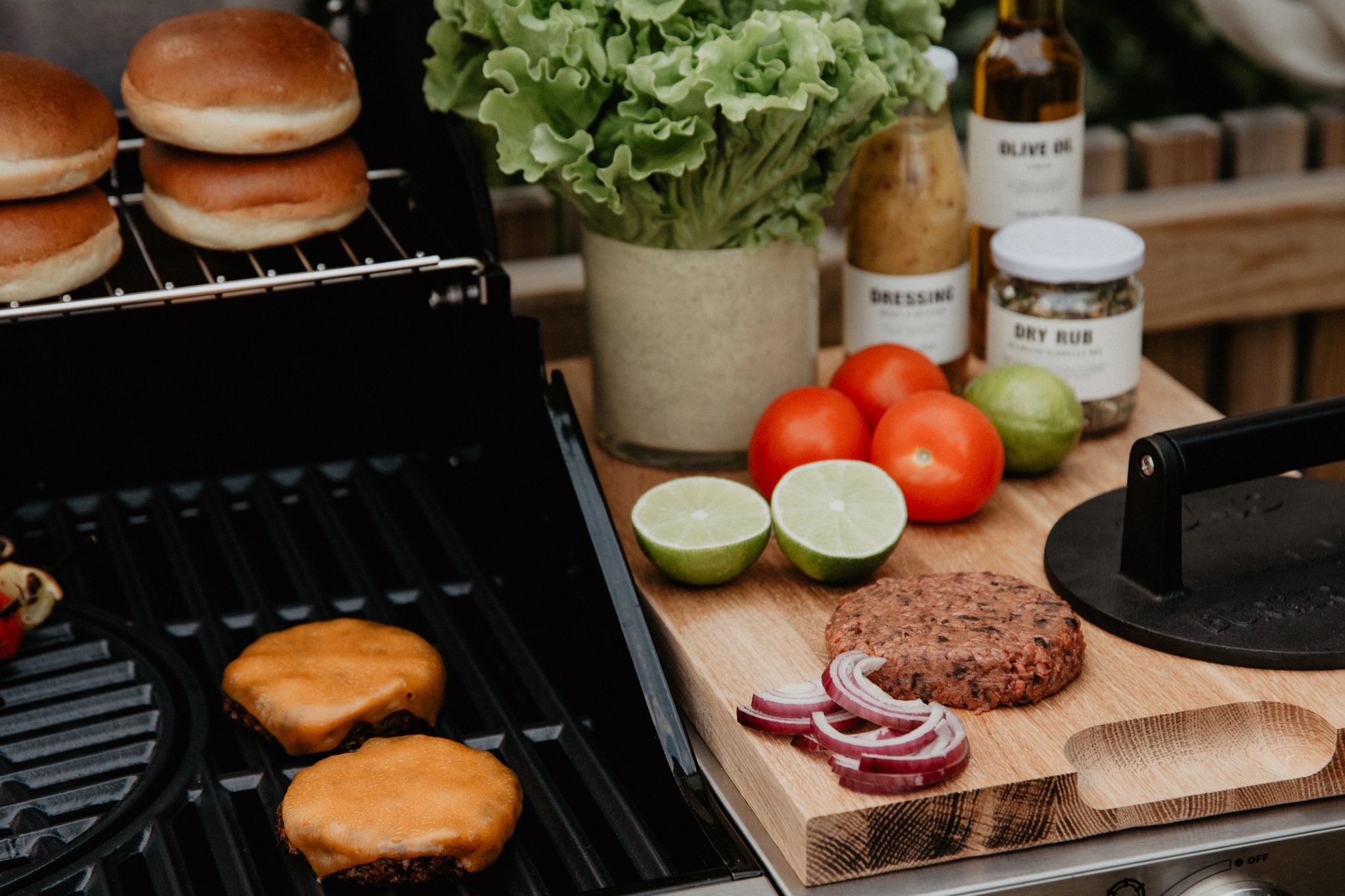 Grillade burgare och tillbehör på en utomhusgrill