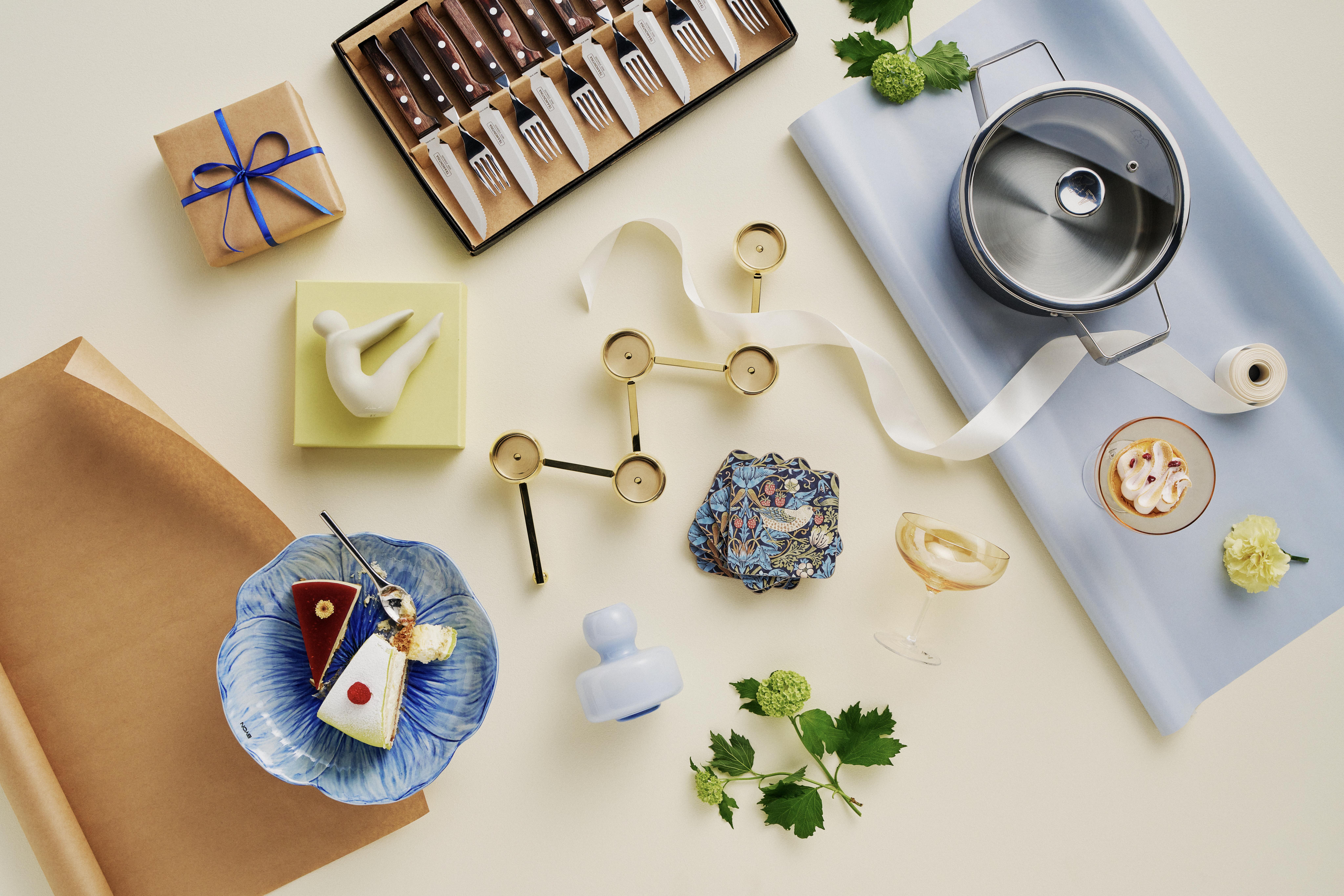 Et blått blomsterformet fat med et kakestykke og en messinglysestake som gaveidé