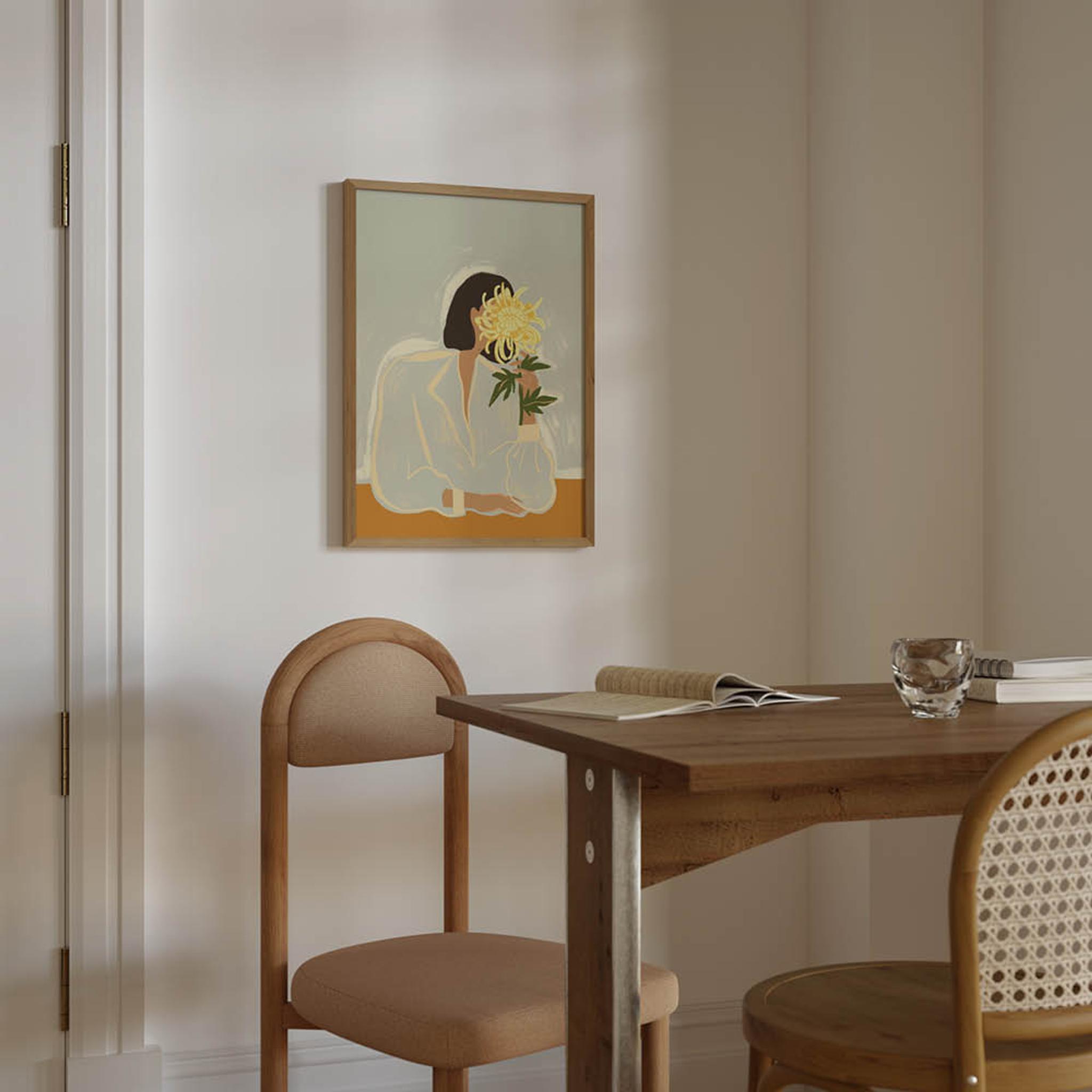Ljust matrum med träbord, stoppade stolar och en tavla av en person som håller en blomma framför ansiktet.