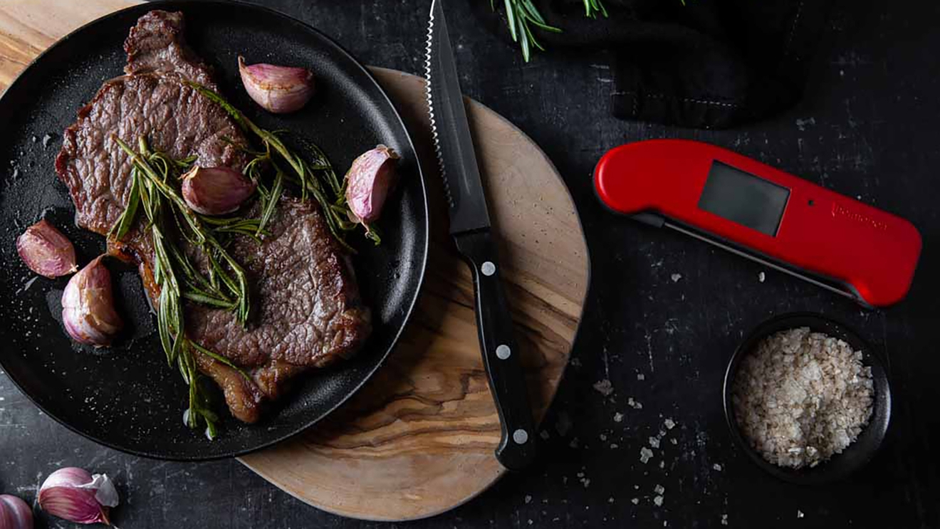 ETI kökstermometer röd med tillagat kött och vitlök vid sidan