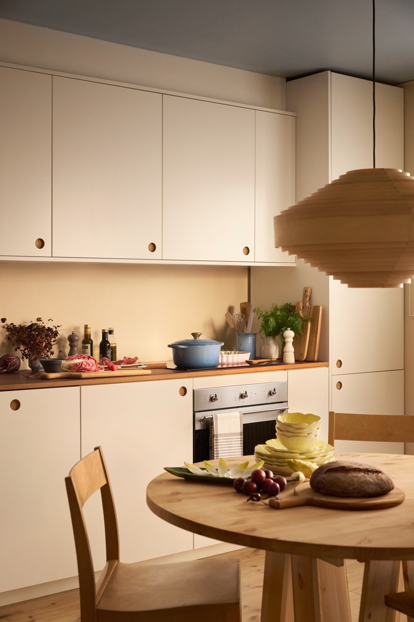 Beiget kök med trä bänkskiva och runt matbord