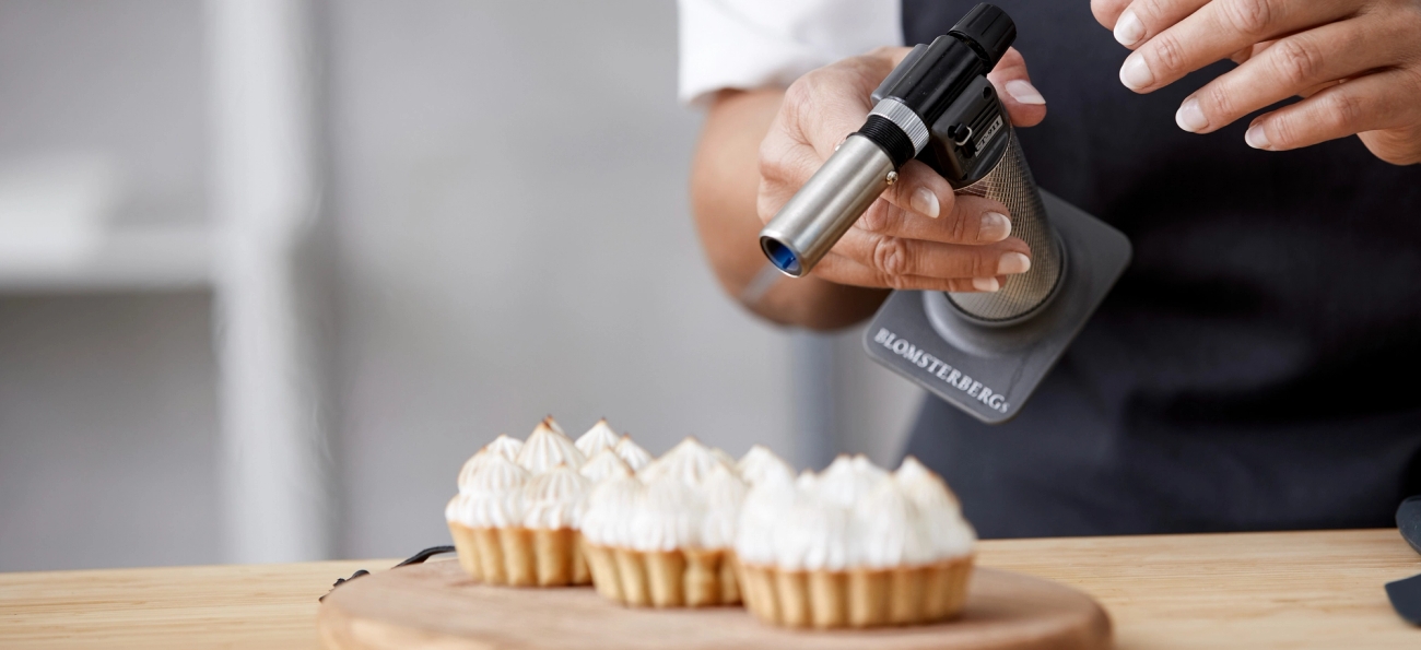 Brûléebrenner i sølv som brenner et bakverk